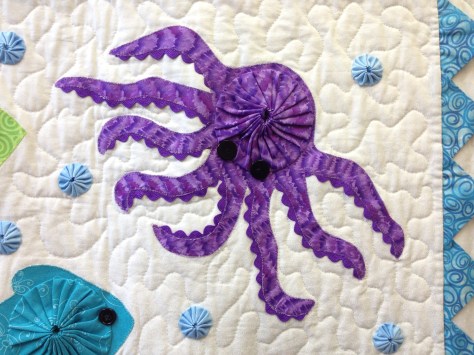 A detail look at the way the yo-yos are incorporated into larger quilts.