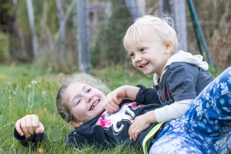 kids rolling in the grass